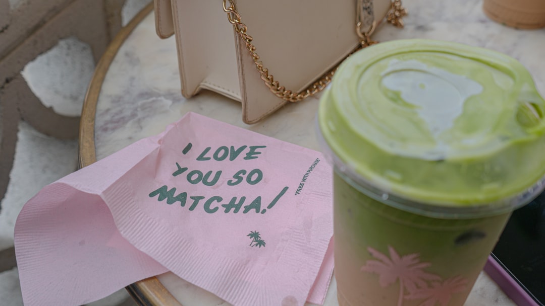 A glass of iced matcha latte with visible layers of green matcha and milk over ice